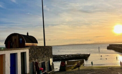 Coastal promenade at sunset with serene sea view, inviting atmosphere, perfect for evening strolls near the hotel.