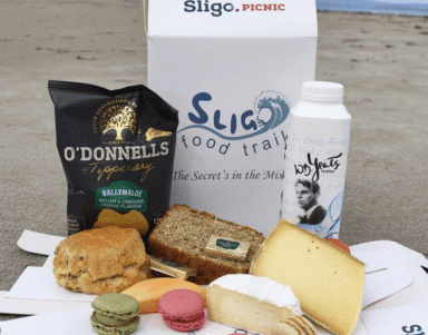 Indulge in a seaside picnic with local cheese, artisan bread, and gourmet treats, showcasing Ireland's culinary delights.