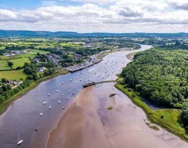 Scenic river view with boats and lush countryside, perfect for relaxation near countryside hotel, guests enjoy peaceful nature.